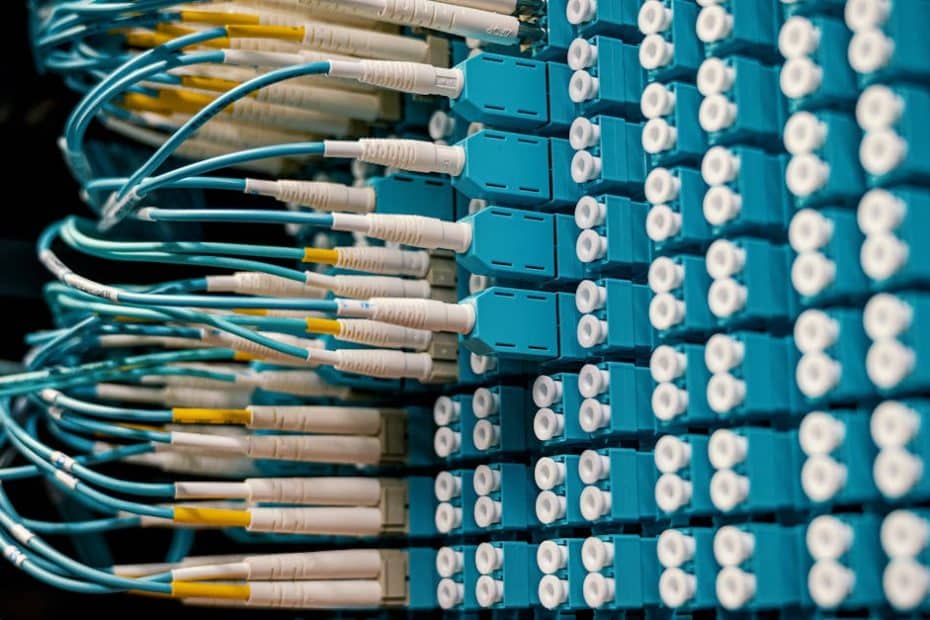 close up of a network patch panel with connected blue fiber optic cables